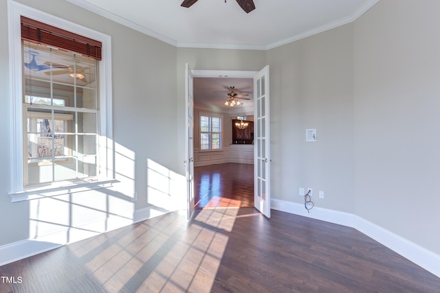 spare room with dark wood-type flooring, crown molding, ceiling fan with notable chandelier, and french doors