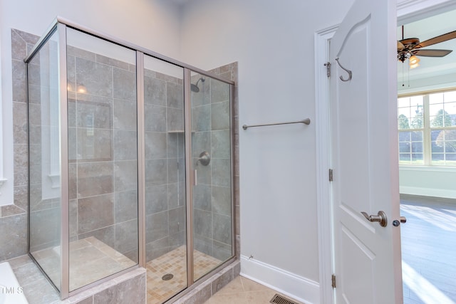 bathroom with tile patterned flooring, a shower with shower door, and ceiling fan