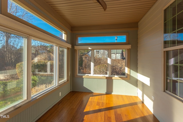 unfurnished sunroom with a healthy amount of sunlight and wooden ceiling