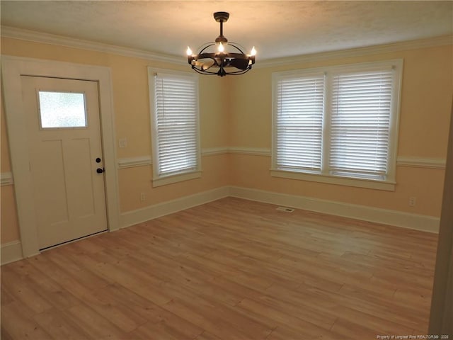 entryway featuring an inviting chandelier, crown molding, and light wood-type flooring