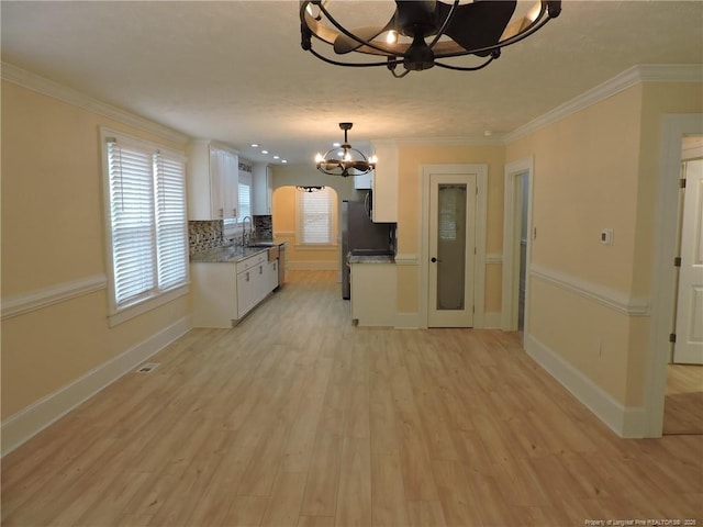 kitchen featuring white cabinetry, sink, ornamental molding, and light hardwood / wood-style flooring