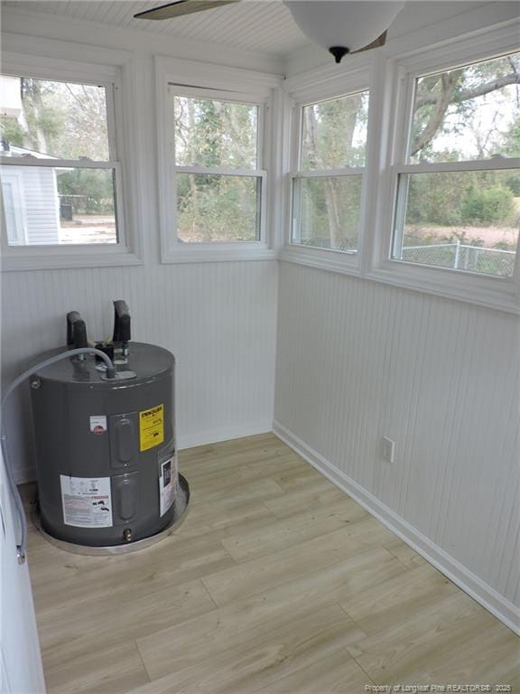 unfurnished sunroom featuring electric water heater and a healthy amount of sunlight