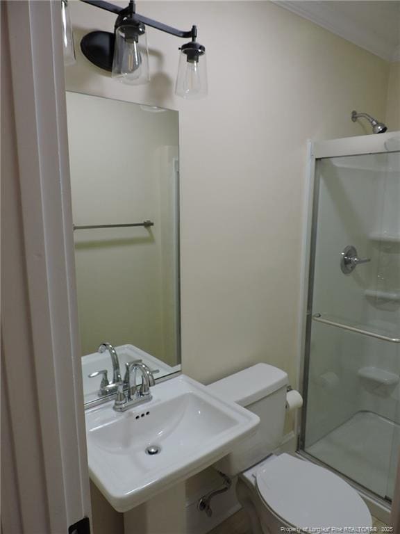 bathroom featuring toilet, an enclosed shower, and sink