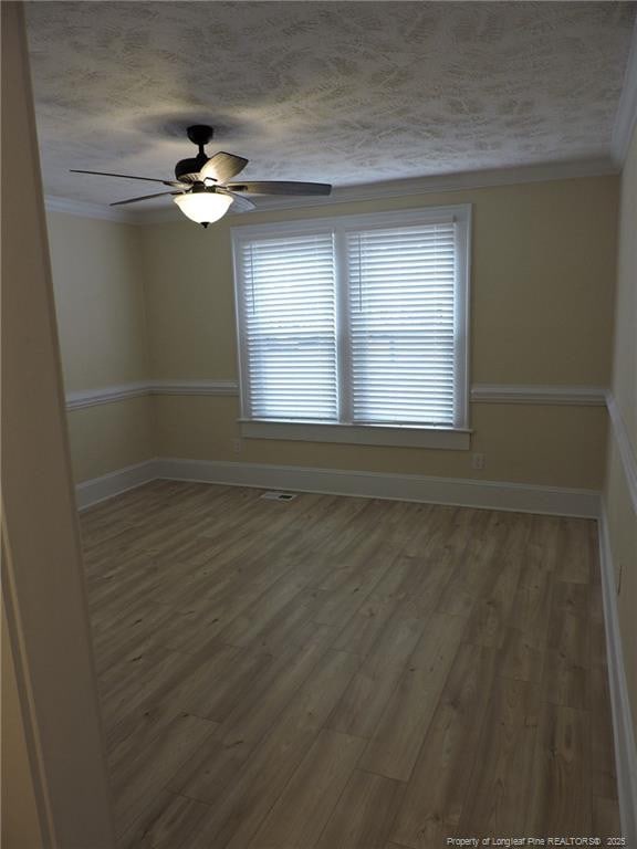 unfurnished room with crown molding, ceiling fan, hardwood / wood-style floors, and a textured ceiling