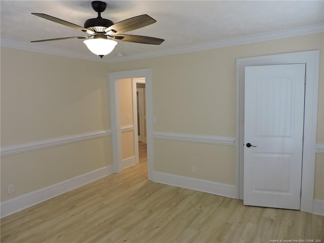 spare room with crown molding, ceiling fan, and light wood-type flooring