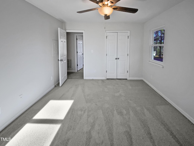 unfurnished bedroom with light colored carpet, ceiling fan, and a closet