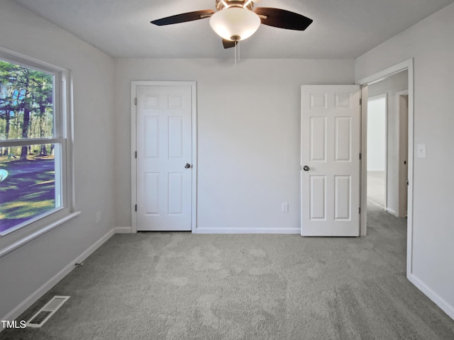 unfurnished bedroom with light carpet and ceiling fan