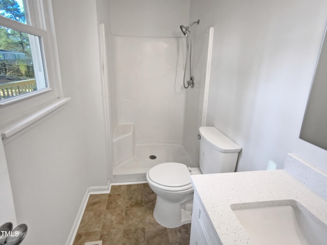 bathroom with a shower, vanity, and toilet