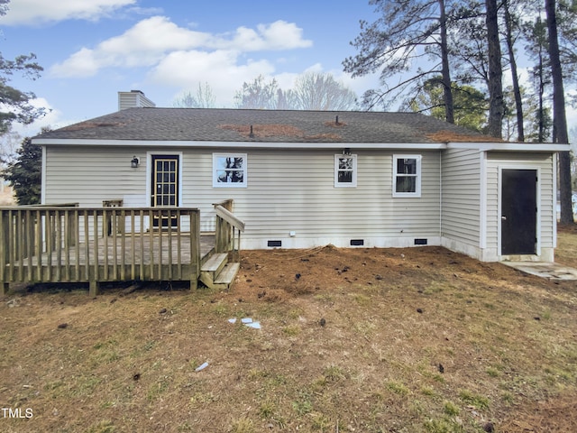 rear view of property with a wooden deck and a lawn