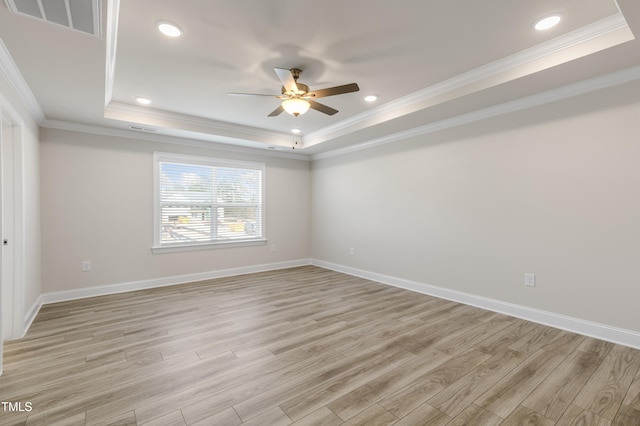 unfurnished room with crown molding, a raised ceiling, and light hardwood / wood-style flooring