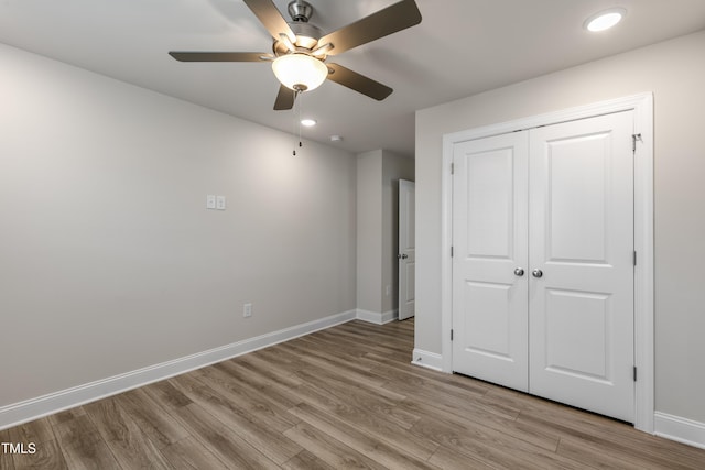 unfurnished bedroom featuring ceiling fan, light hardwood / wood-style floors, and a closet