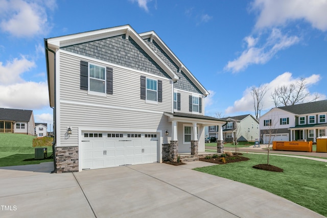 craftsman inspired home with cooling unit, a garage, and a front lawn