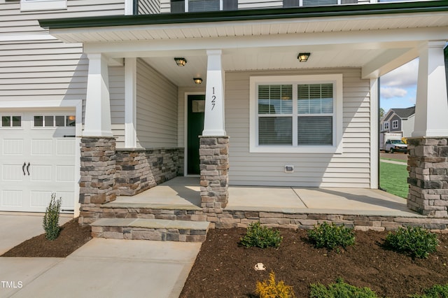 doorway to property with a garage and covered porch