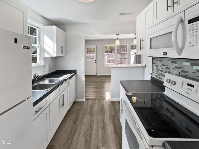 kitchen featuring sink, white cabinetry, dark hardwood / wood-style flooring, white appliances, and decorative backsplash