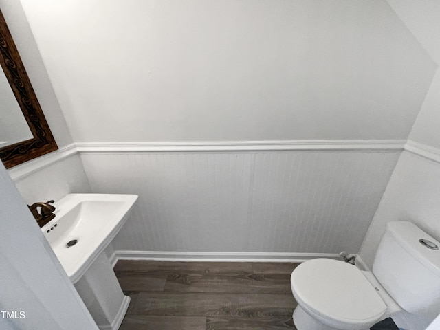 bathroom with hardwood / wood-style flooring, sink, and toilet