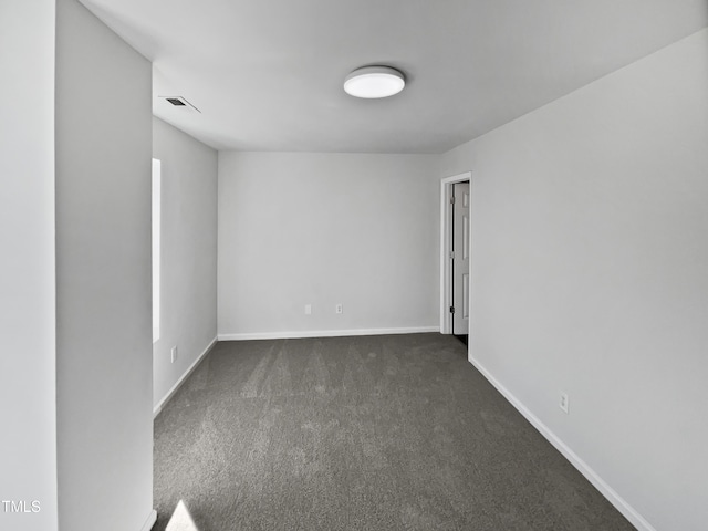 empty room featuring dark carpet