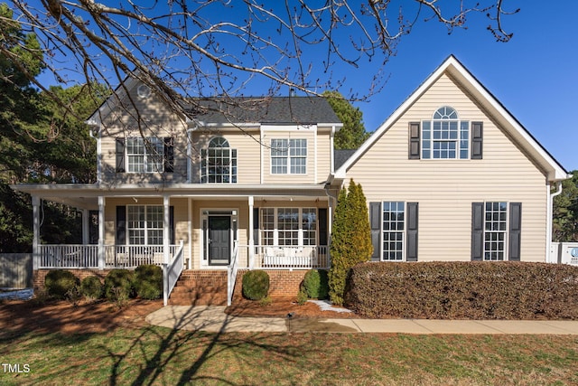 traditional home featuring a porch and a front lawn