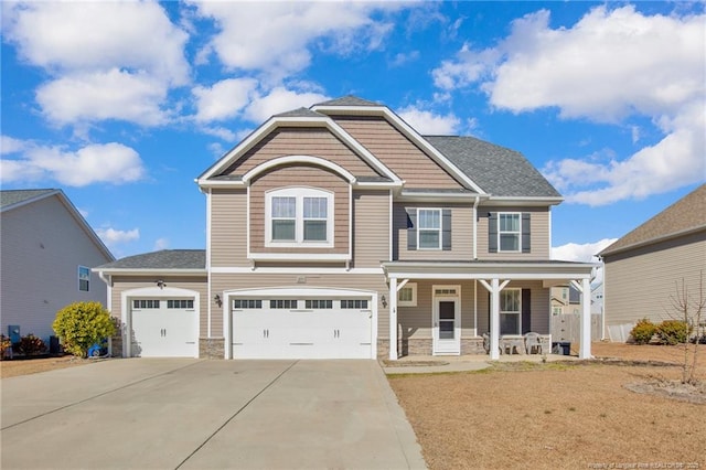 craftsman-style home with a porch, a garage, and a front yard