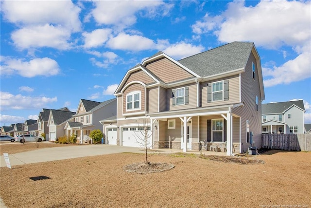 craftsman inspired home with a porch, an attached garage, fence, a residential view, and driveway