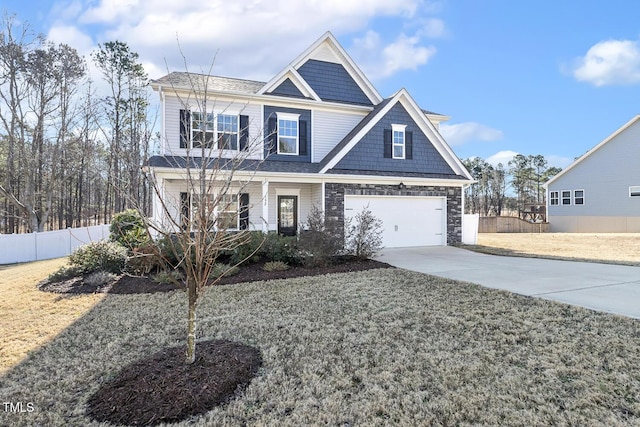 view of front facade with an attached garage, fence, stone siding, driveway, and a front lawn