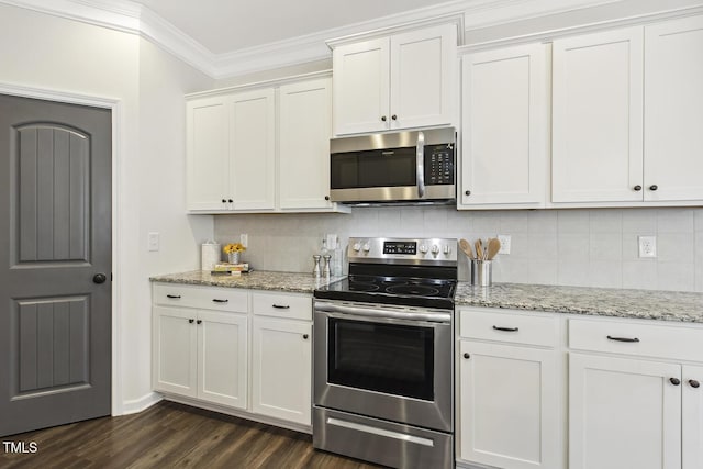 kitchen with appliances with stainless steel finishes, white cabinetry, ornamental molding, and backsplash