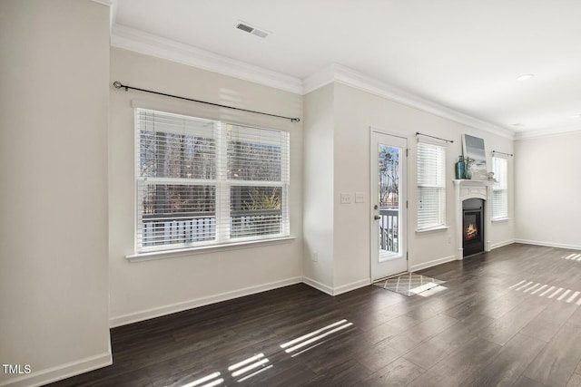 foyer featuring visible vents, baseboards, a glass covered fireplace, dark wood-style flooring, and crown molding