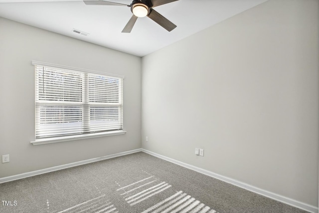 carpeted empty room featuring baseboards, visible vents, and a ceiling fan