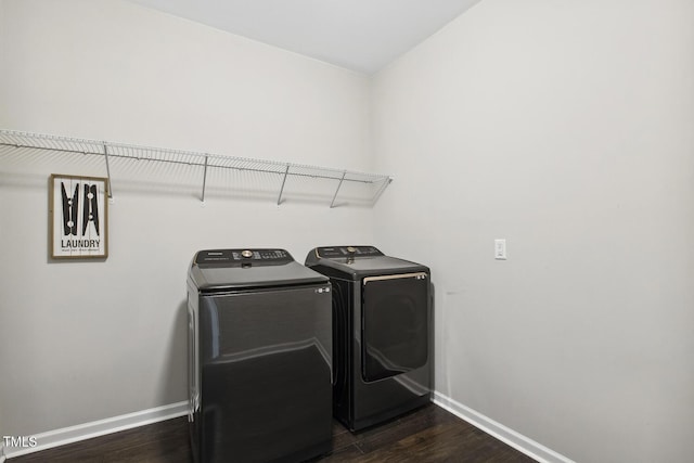 laundry area featuring laundry area, dark wood-style floors, baseboards, and washing machine and clothes dryer