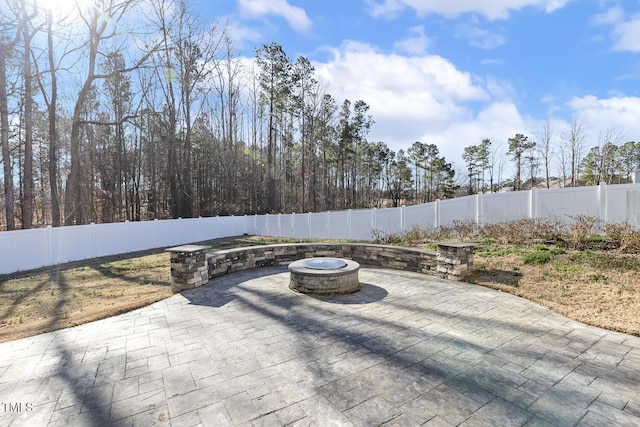 view of patio featuring a fenced backyard and a fire pit