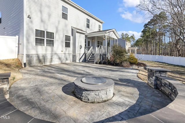 view of patio / terrace featuring covered porch, fence, and a fire pit