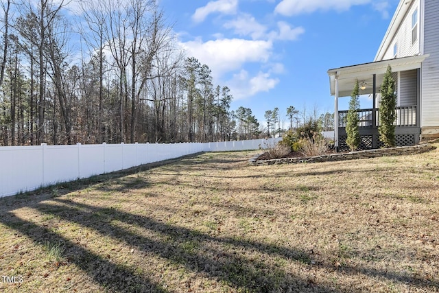 view of yard featuring a porch and fence