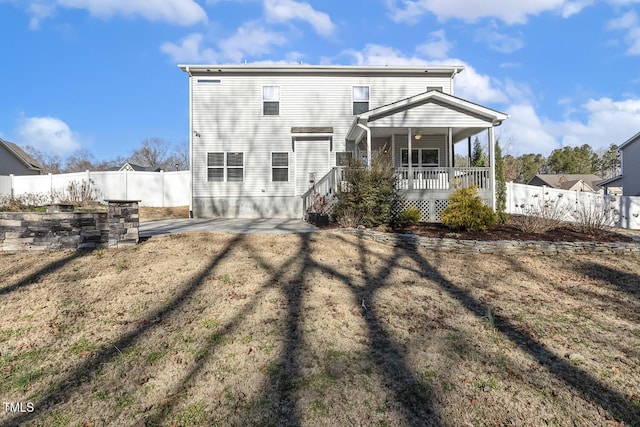 back of property with a porch, a patio area, a fenced backyard, and a yard