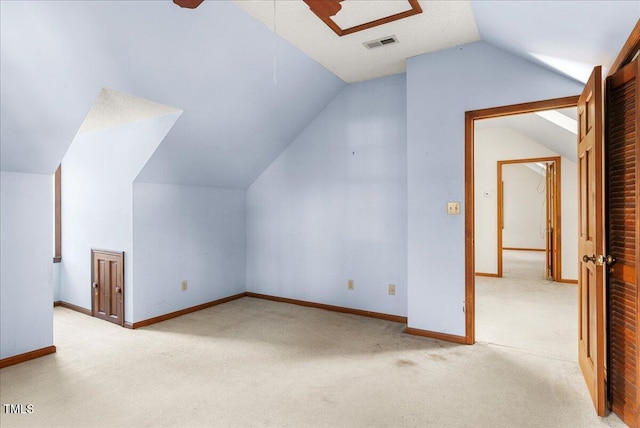 bonus room with vaulted ceiling and light colored carpet