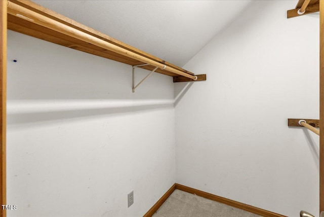 walk in closet with lofted ceiling and carpet floors