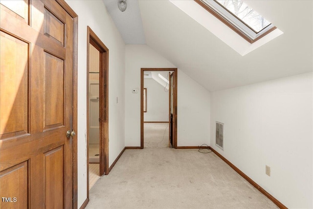 additional living space featuring lofted ceiling with skylight and light carpet