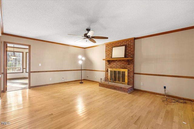 unfurnished living room with ornamental molding, a brick fireplace, a textured ceiling, and light hardwood / wood-style floors