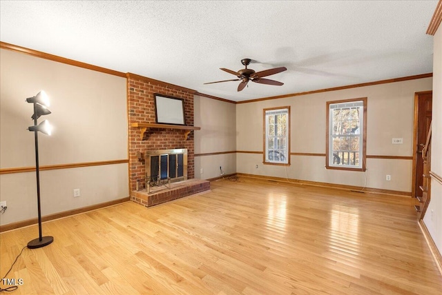 unfurnished living room with ornamental molding, a fireplace, light hardwood / wood-style floors, and a textured ceiling