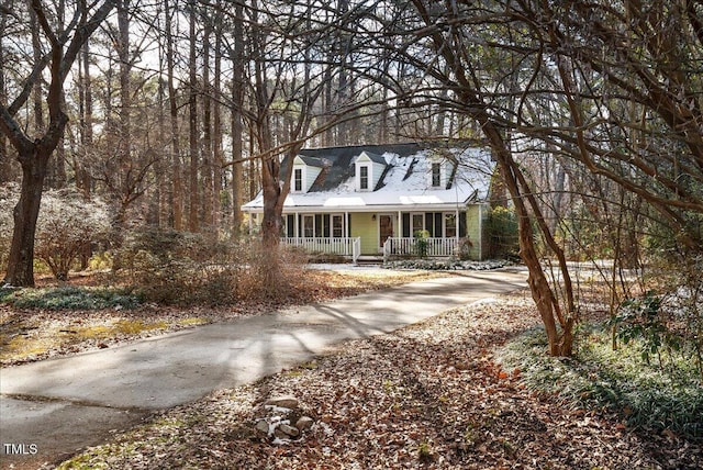 cape cod house featuring a porch