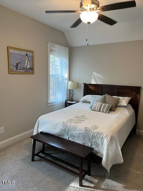 carpeted bedroom with ceiling fan and vaulted ceiling