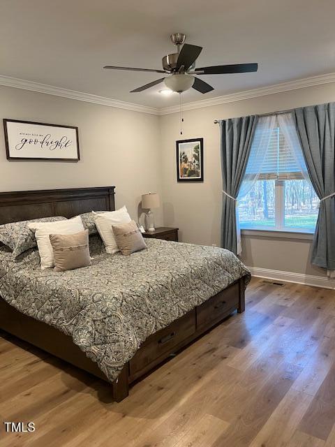 bedroom with wood-type flooring, ceiling fan, and crown molding