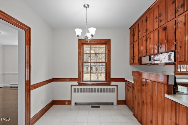 kitchen with radiator, hanging light fixtures, a baseboard heating unit, light tile patterned floors, and an inviting chandelier