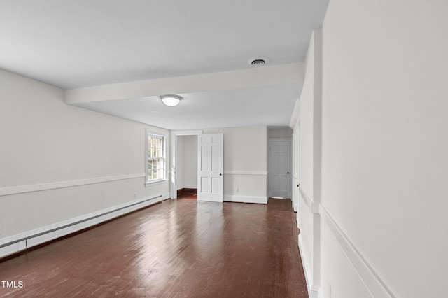 empty room featuring a baseboard radiator and dark hardwood / wood-style flooring