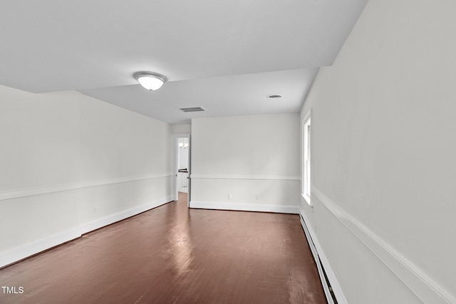 unfurnished room featuring a baseboard radiator and dark hardwood / wood-style floors