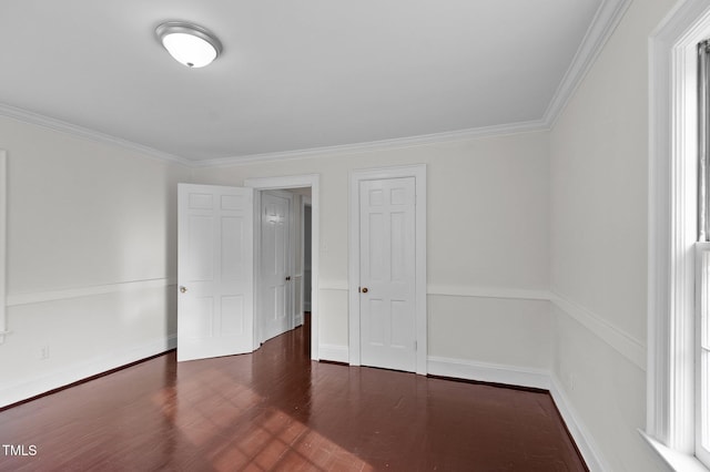 spare room featuring ornamental molding and dark hardwood / wood-style floors