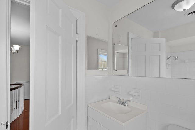 bathroom featuring vanity, tile walls, and walk in shower