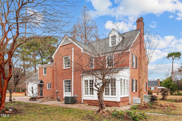 view of front of property featuring central AC unit, a front yard, and a patio