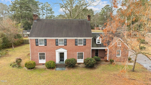 colonial inspired home with a front lawn