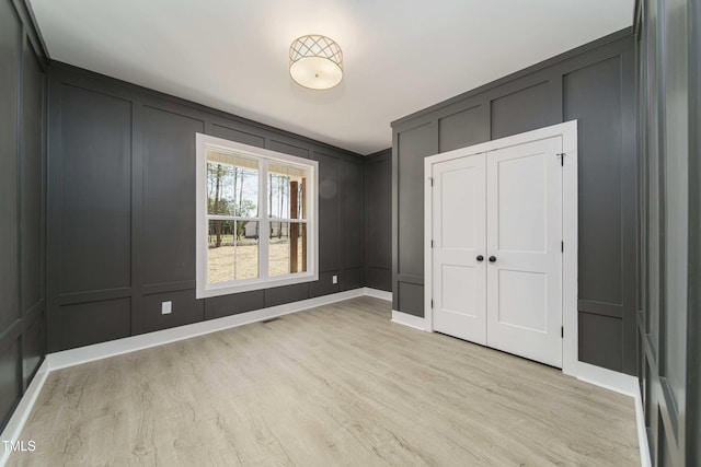 unfurnished bedroom with a closet and light hardwood / wood-style flooring