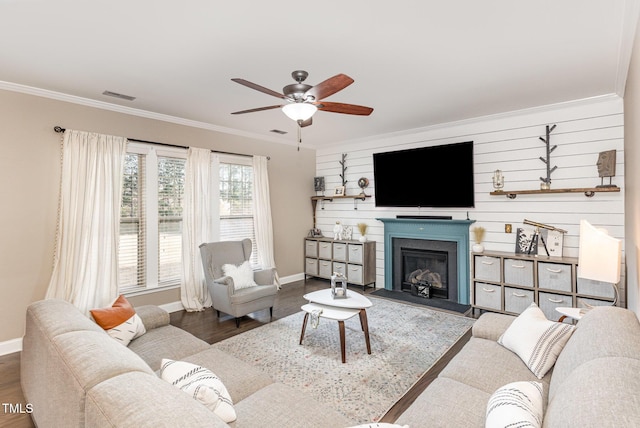 living room featuring ceiling fan, ornamental molding, and dark hardwood / wood-style floors