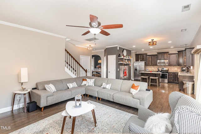 living room featuring sink, ornamental molding, dark hardwood / wood-style floors, and ceiling fan